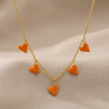 Minimalist gold heart charm necklace with orange accents displayed as trendy fashion jewelry